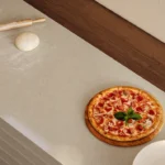 Caesarstone ICON 4201 Organic Dune beige surface featured in a modern restaurant interior with a pizza oven island countertop and warm wood accents