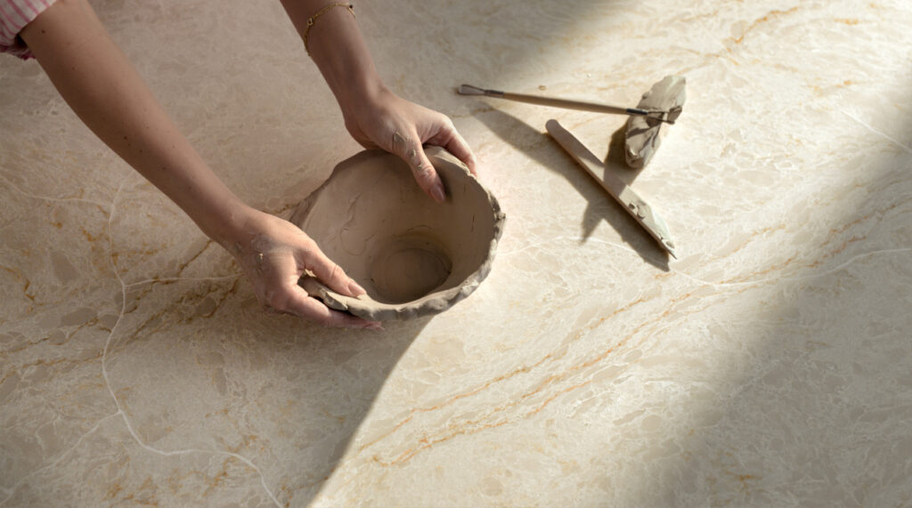 Caesarstone ICON 8251 Taj Whisper white surface with hands and bowl