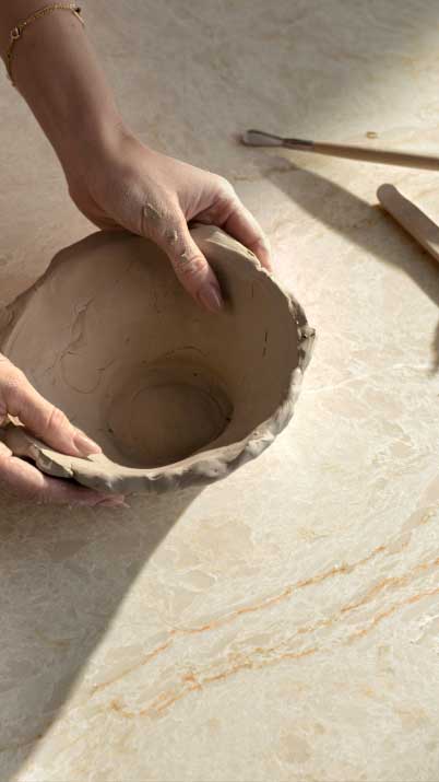 Caesarstone ICON 8251 Taj Whisper white surface with hands and bowl